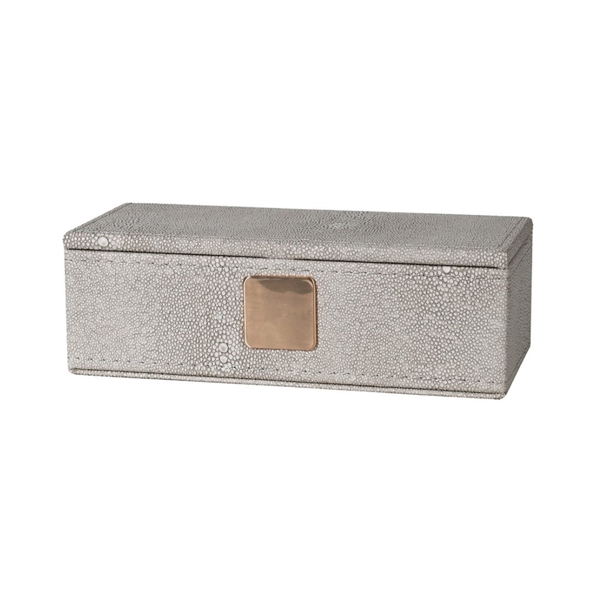 Faux shagreen lidded trinket box in ivory colour. The small circular texture of the shagreen skin is in a pale grey, giving it a two tone effect. The box has a matt gold sqaure badge on the front.
Dimensions: H:60 W:180 D:80 mm